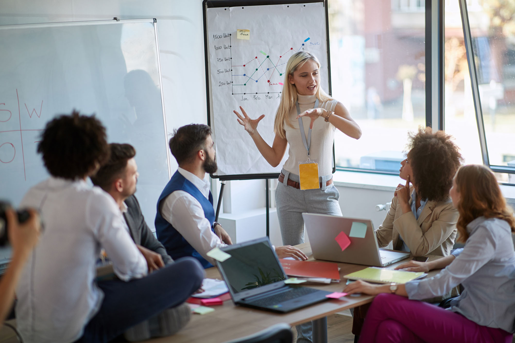 Woman presenting to a conference table of people